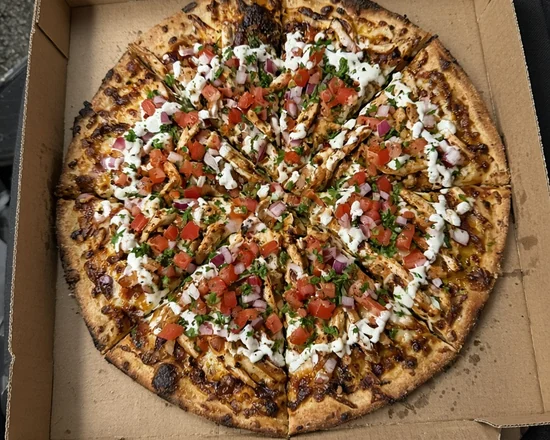 Sliced chicken shawarma pizza with garlic sauce in a pizza box